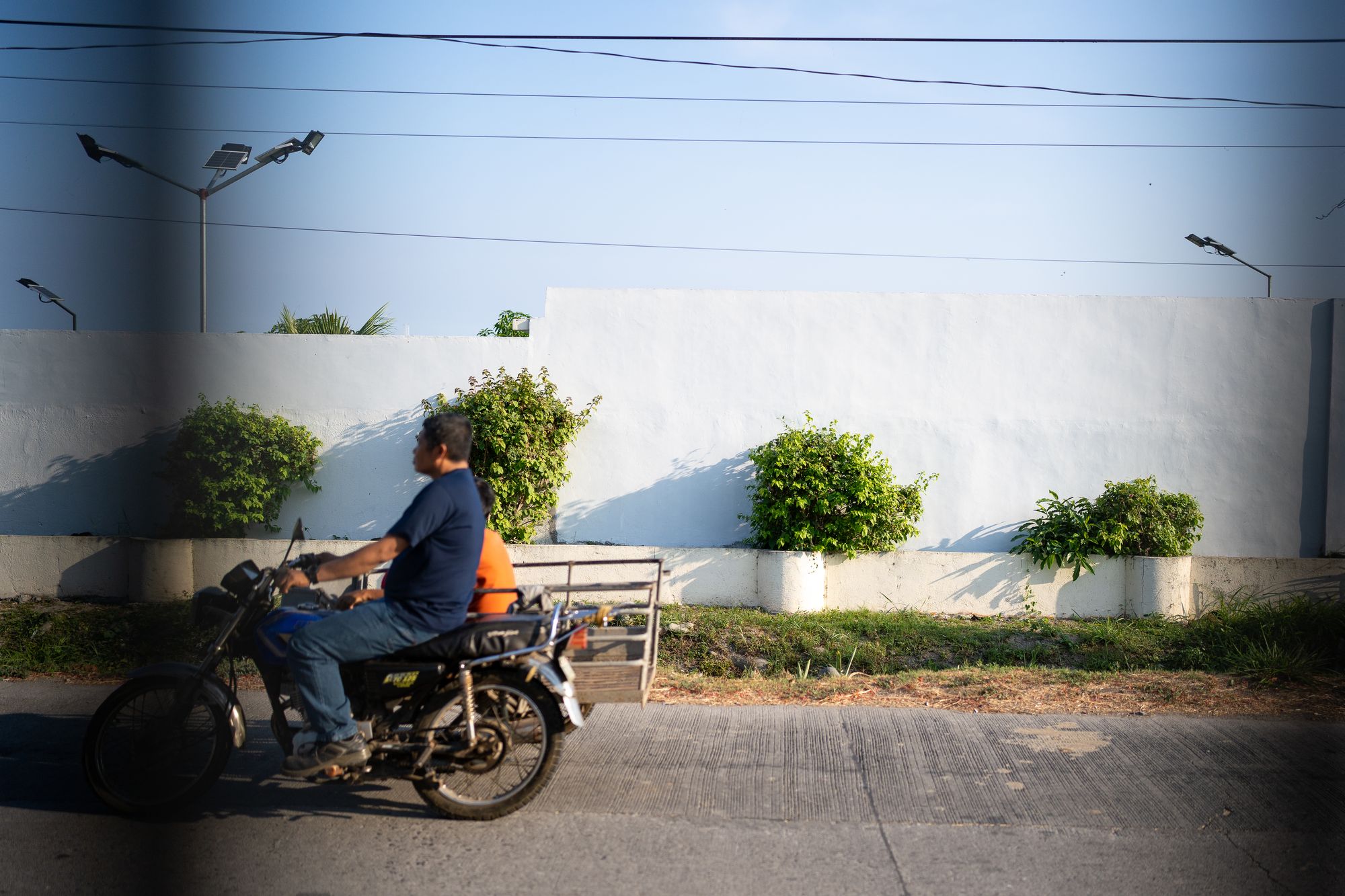 Man riding a motorcycle with a wagon